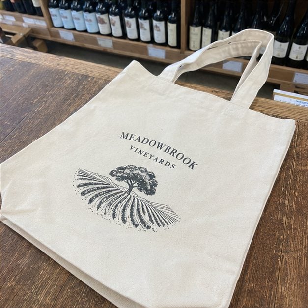 Custom cotton canvas wine tote with sturdy handles and an embroidered logo carrying bottles